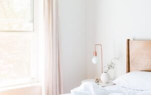 Bright bedroom with white bedding and a small bedside lamp