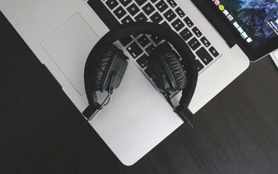 Black over-ear headphones resting on a laptop keyboard