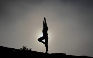 Silhouette of a person balancing in a standing stretch at sunset