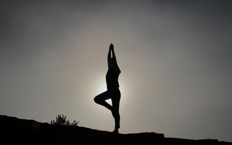 Silhouette of a person balancing in a standing stretch at sunset