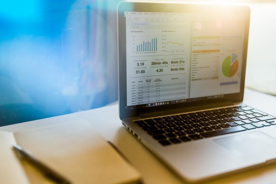 Laptop showing charts on a sunny desk