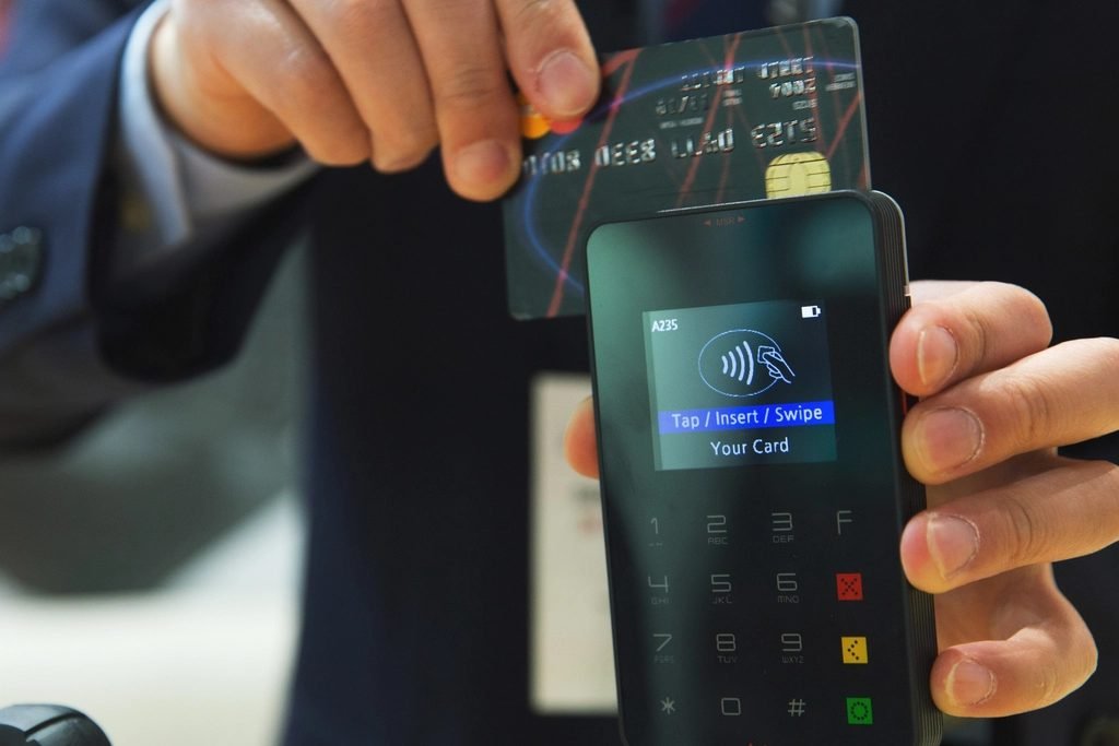 Payment card held above a contactless card reader