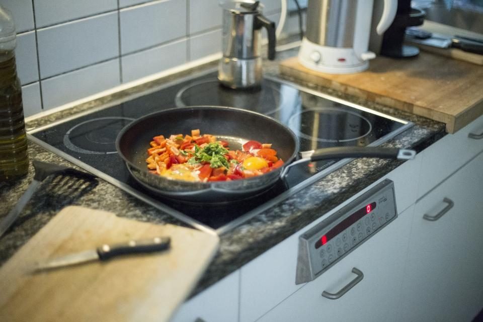 Frying pan of vegetables cooking on an induction hob
