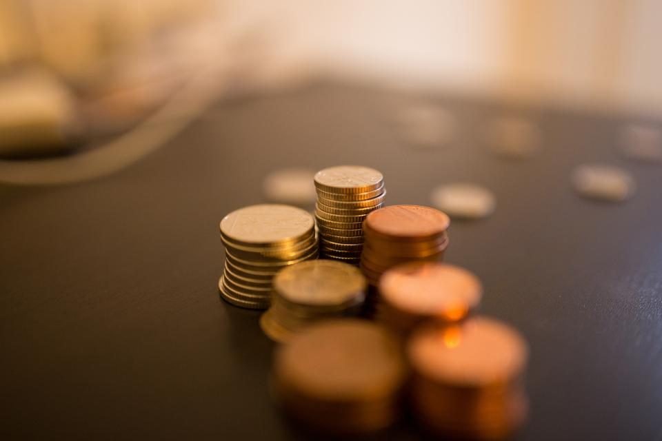Small stacks of coins on a dark wooden table