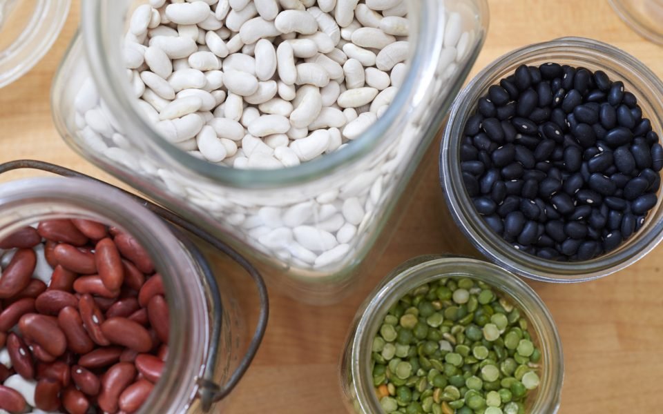 Glass jars of dried white, black and red beans and split peas