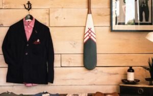 Navy blazer and pink shirt hanging on a wooden wall
