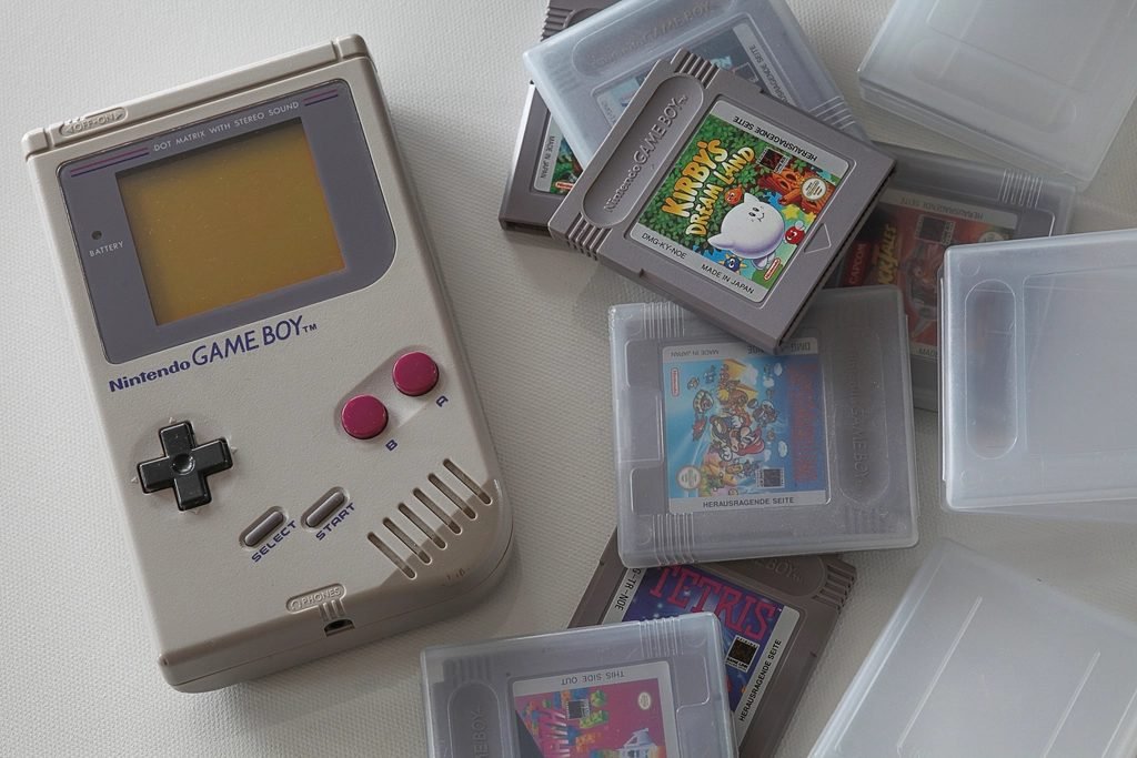 Classic handheld game console surrounded by game cartridges