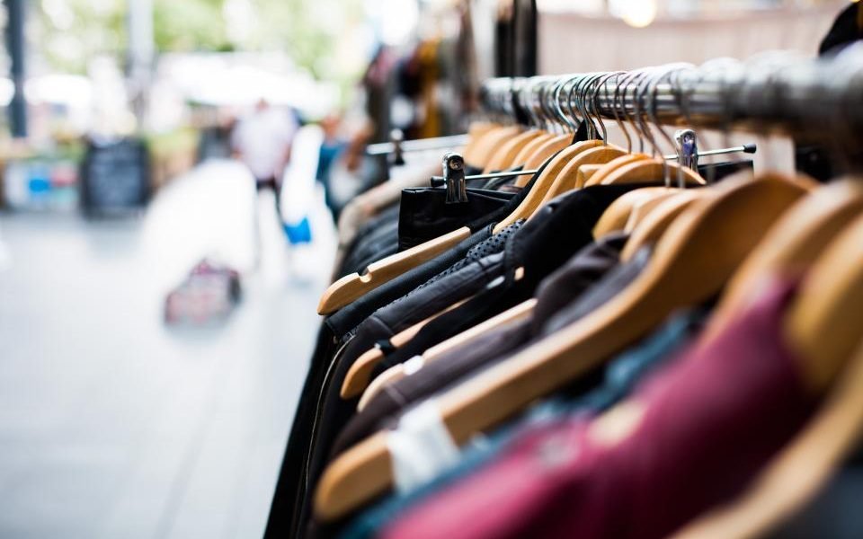 Rail of second-hand clothes on hangers at a street market