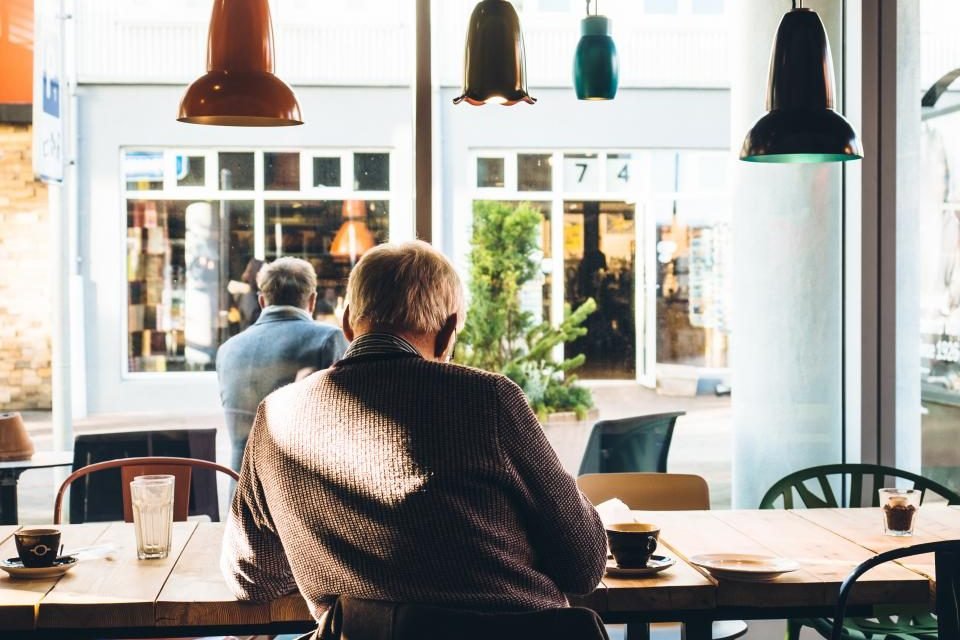 People sitting at tables in a bright neighborhood cafe