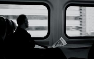 Passenger looking out of a train window, in black and white