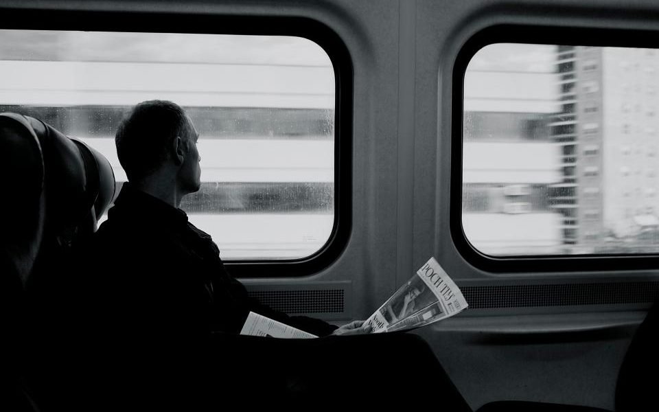 Passenger looking out of a train window, in black and white