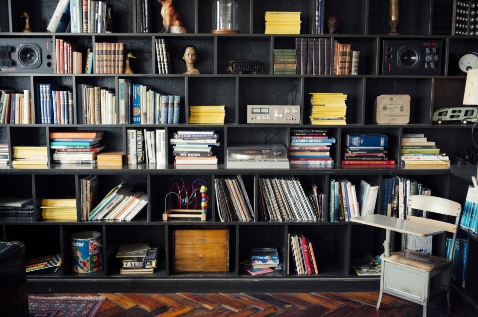 Wall of open shelves holding books, boxes and decorations