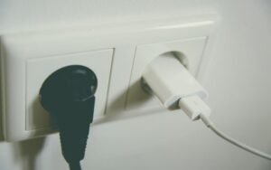 Two plugs in a white double wall socket