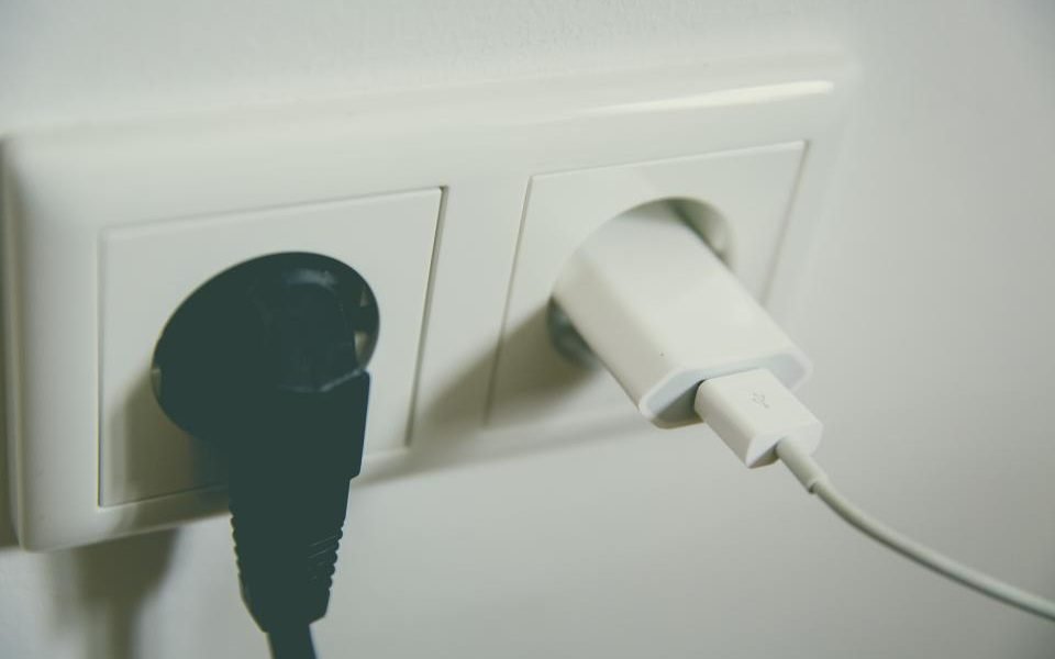 Two plugs in a white double wall socket
