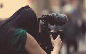 Person filming with a video camera fitted with a microphone