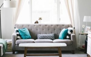 Tidy living room with a grey sofa, teal cushions and a wooden coffee table